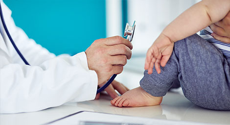 doctor showing stethoscope to patient who is a child